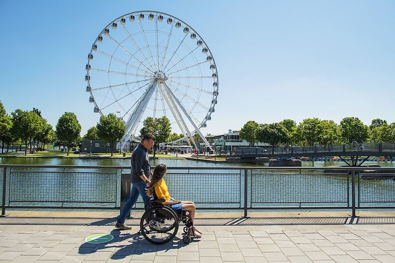 Personne à mobilité réduite devant la Grande Roue de Montréal - Canada