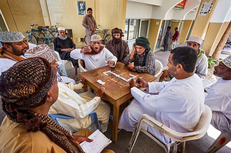 Hommes jouant au Domino devant la halle du marché de Salalah - Oman